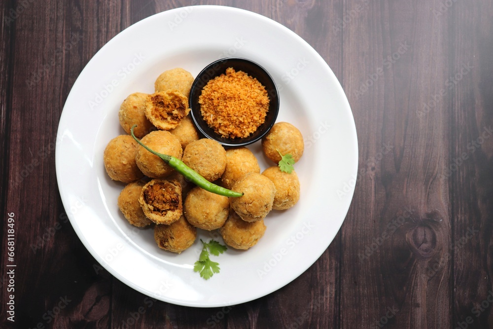 Dry Kachori is a deep fried crispy and crunchy balls of maida flour, stuffed with aspicy mix of gram flour, sev, Lentils, Tamarind chutney and other Indian spices. A popular tea time snack. Copy Space - obrazy, fototapety, plakaty 