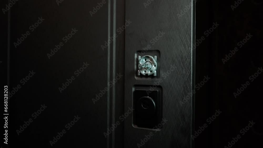 a master installs doors to an apartment in a house, a drill tool close-up drills a wall a master installs doors to an apartment in a house, a drill tool close-up drills a wall