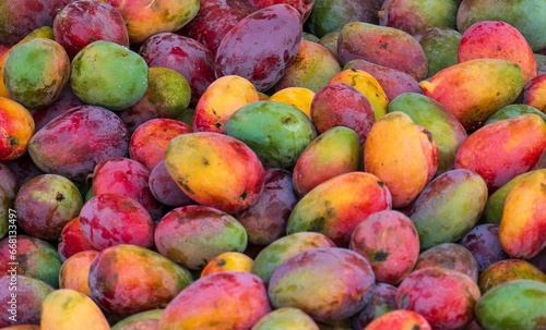 Close-up shot of a pile of ripe mangoes in a market stall