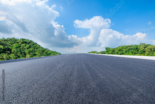 Highway and green tree landscape under blue sky © ABCDstock