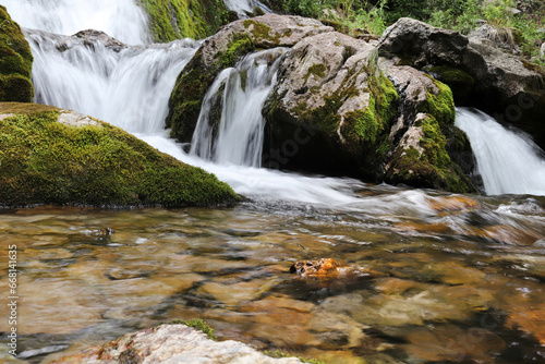 A natural waterfall flowing down rugged rocks covered in moss