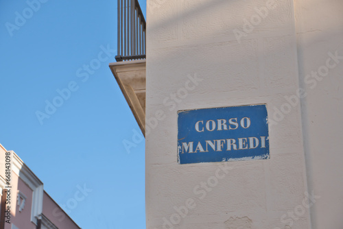 Fototapeta Naklejka Na Ścianę i Meble -  A sign with the street name Corso Manfredi on a house facade in Manfredonia, Apulia, Italy