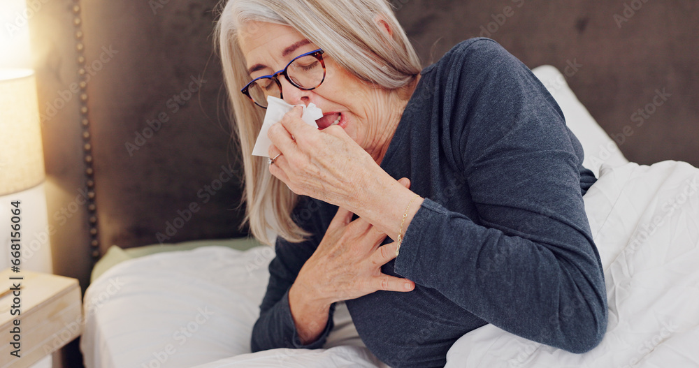 Sick, blowing nose and senior woman in bed with allergies, flu or cold on weekend morning at home. Illness, sneezing and elderly female person in retirement with tissue for sinus in bedroom at house. - obrazy, fototapety, plakaty 