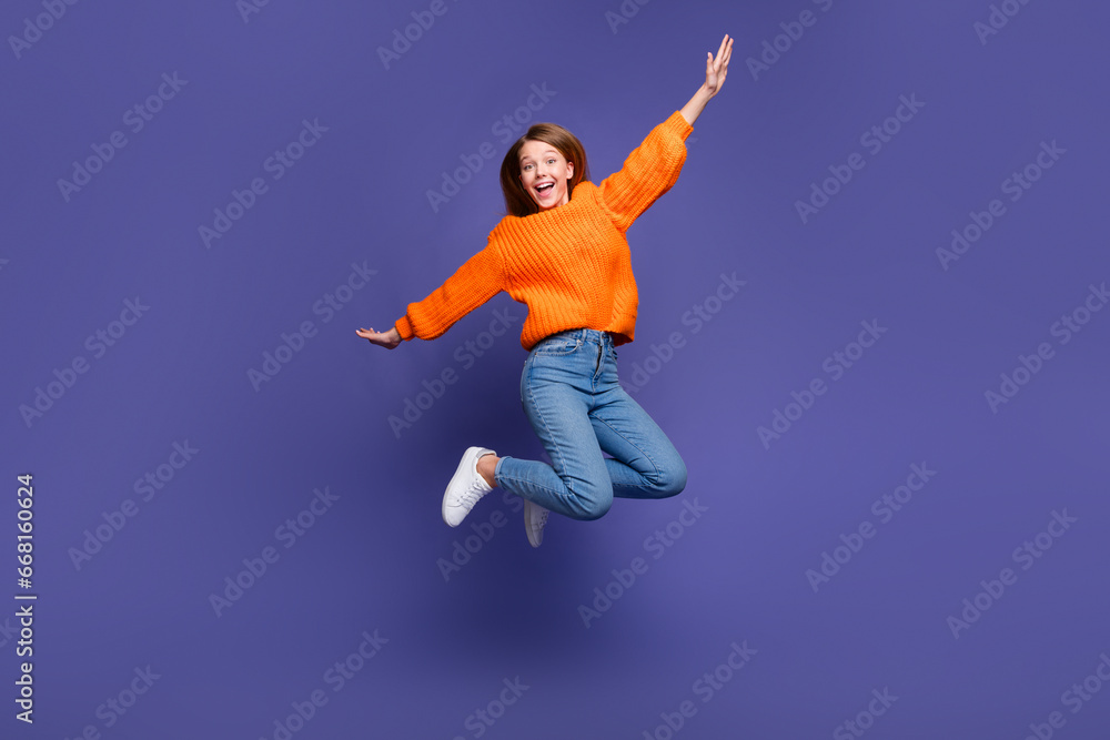 Full length photo of young teenage girl jumping trampoline looks like she flying with wings hands isolated on violet color background