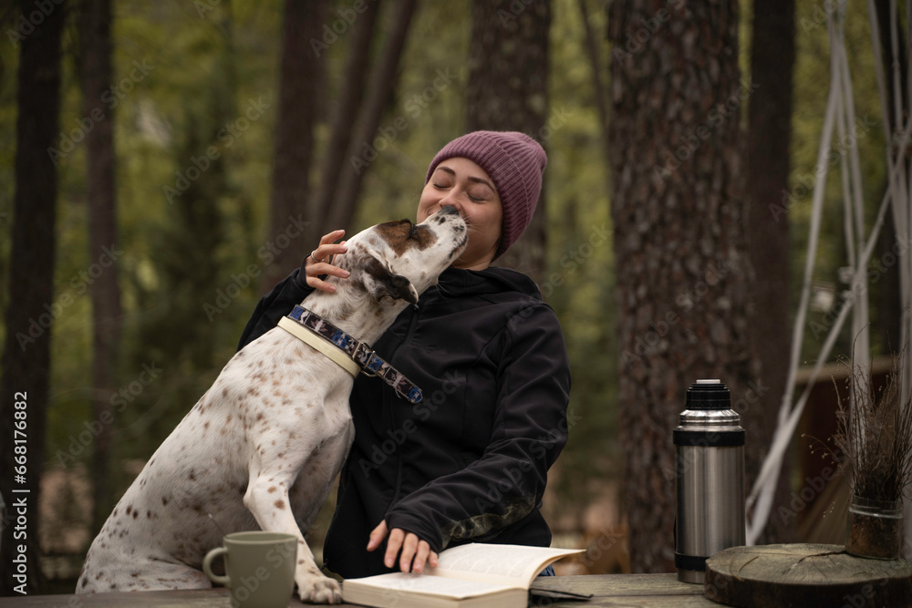 Φωτογραφία Chica con sombrero de invierno está sentado y acariciando a su perro están al ai