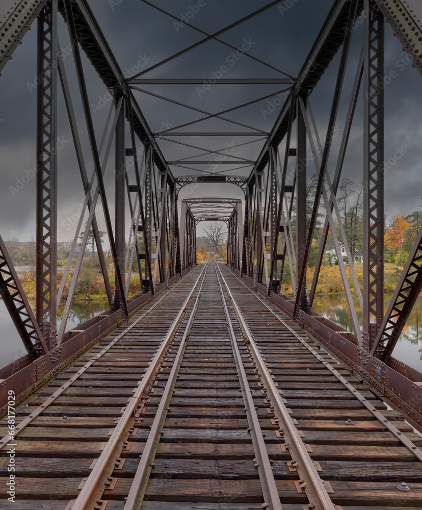 Double span riveted railway truss bridge built in 1893 crossing the Mississippi river in autumn in Galetta, Ontario, Canada