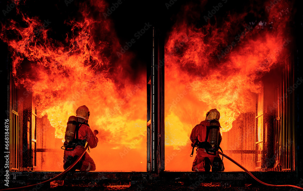 Firefighter Concept. Fireman using water and extinguisher to fighting with fire flame. firefighters fighting a fire with a hose and water during a firefighting training exercise Firefighter Concept. Fireman using water and extinguisher to fighting with fire flame. firefighters fighting a fire with a hose and water during a firefighting training exercise