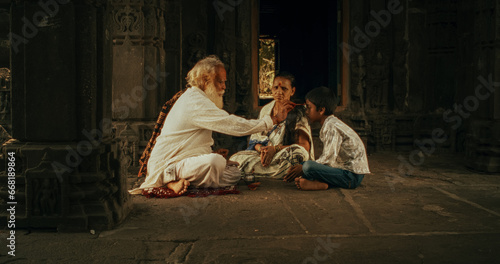 Authentic Footage of Hindu Priest Putting a Tilaka on Female Temple Follower and her Male Kid. Senior Guru Giving Blessings with a Mark on the Forehead to a Small Family, Faithful Worshipers 