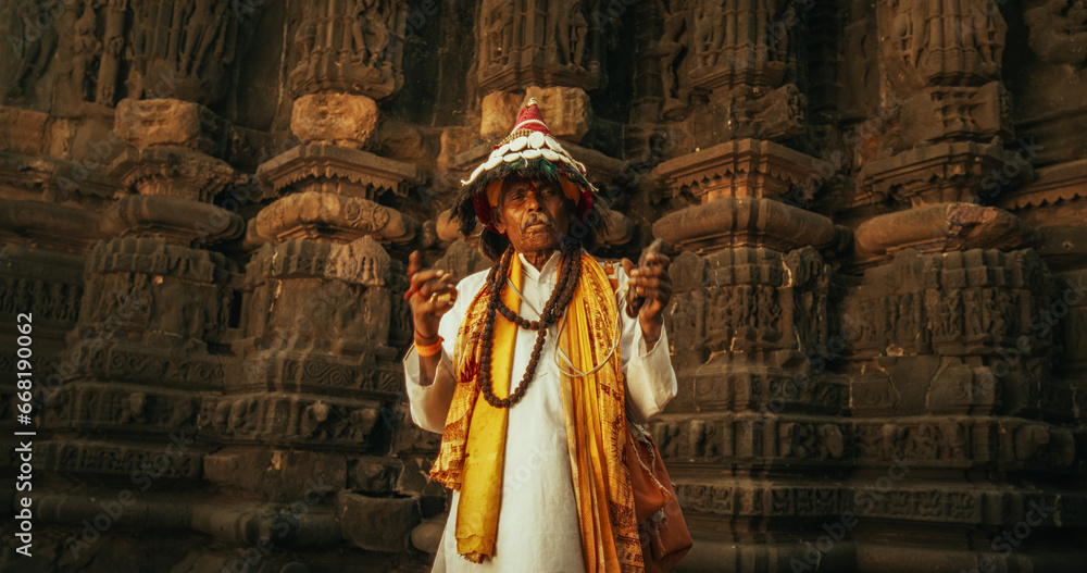 Authentic Portrait of an Old Indian Man in Traditional Attire Playing Instruments in an Ancient Hindu Temple. Festive Senior Male Upholding the Rich Cultural Heritage Through Religious Music