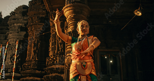 Fotografía Energetic Indian Woman Showcases the Graceful Movement of Her Legs in Traditional Attire while Dancing Bharatanatyam