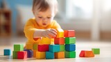 Close up portrait of a sitting on floor and playing with colorful wooden block toys
