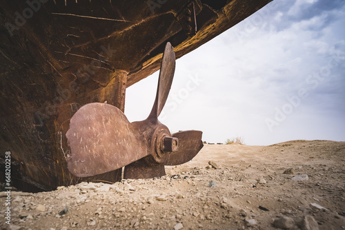 Rusty ships and boats in the desert at the bottom of the dried up Aral Sea in Uzbekistan, an ecosystem tragedy