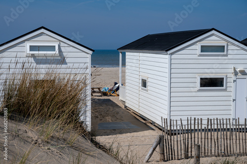Beach holidays on sandy beach, waterfront wooden cottages in Katwijk-on-zee, North sea, Netherlands photo