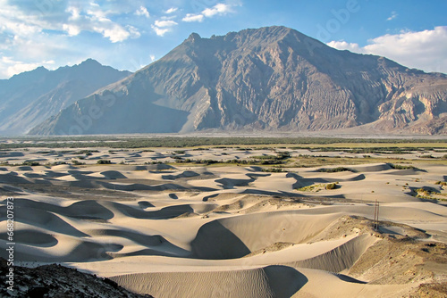 Sand dune pattern with mountain and blue clouds sky background in Nubra valley in Diskit, India. photo