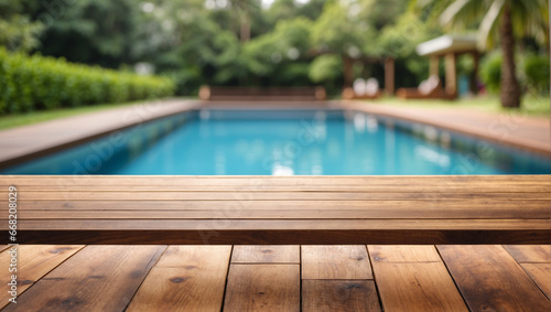 Empty wooden table in front with blurred background of swimming pool