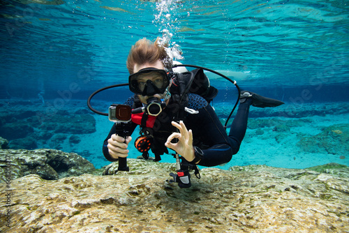 Underwater portrait of a scuba diver swimming near seabed making an ok sign, USA photo