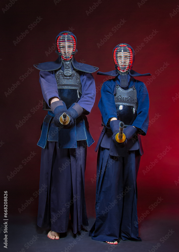 Two kendo fighters with Sinai isolated over dark space. The Japanese martial art of sword fighting, kendo concept. Two kendo fighters with Sinai isolated over dark space. The Japanese martial art of sword fighting, kendo concept.