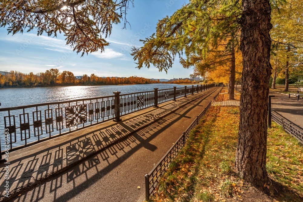 Autumn embankment with trees on the river