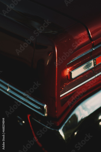 Detailed side view of the dark red exterior of the Classic Sport coupe car with backup lights and stop light