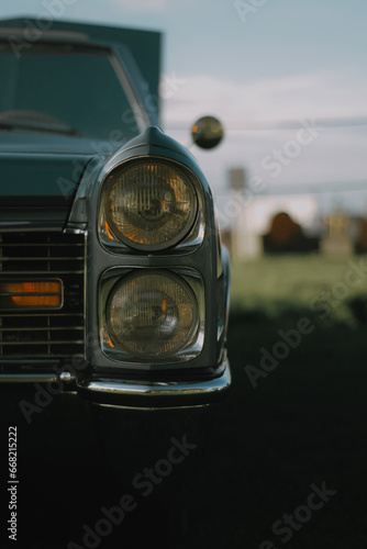 Vintage classic Chevrolet car front view with headlights, blurred background 