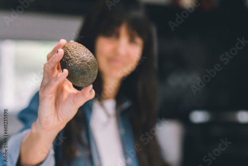 Woman showing an avocado. Copy space