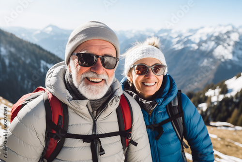 Happy smiling elderly couple with sunglasses hiking in the Alp mountains.