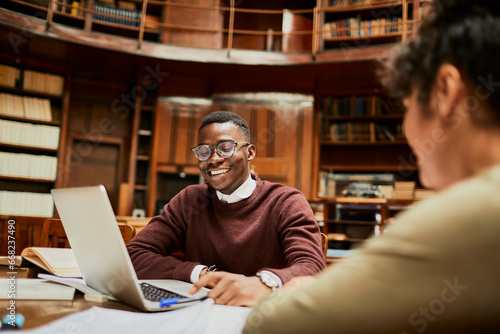 Joyful student engaged in online research at a university library