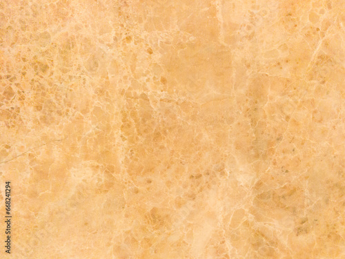An old marble wall with scuffs and damage. Yellow marble background.