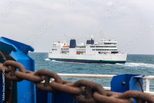 Big modern shuttle passenger freight cargo ferry boat vessel ship with loaded cars and vehicles floating Baltic or North sea . Sea transportation ferryboat transport carrier. Northern Europe sea line photo