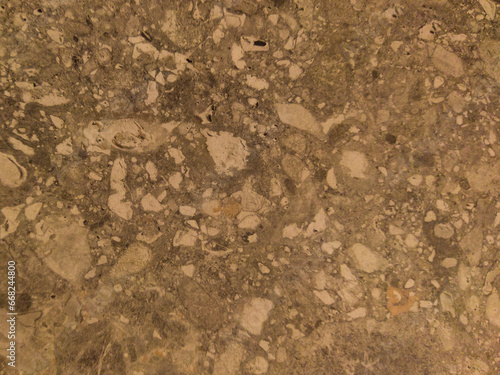 Old yellow surface with dots. Yellow background with a pattern. Concrete floor with stones.
