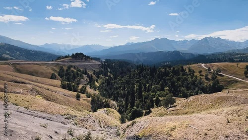 The Arkasara Plateau. Movement of white cumulus clouds over the Arcasara ridge on a sunny day against a bright blue sky. The pass from Arkhyz to Phia, Caucasus, Russia 4K photo