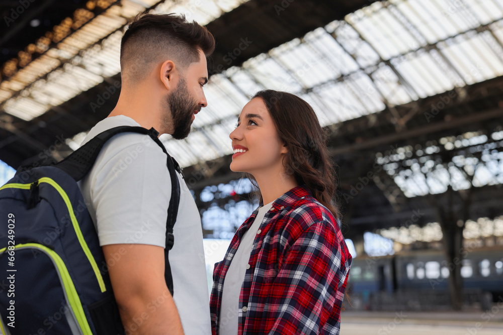 Long-distance relationship. Beautiful couple on platform of railway station, space for text Long-distance relationship. Beautiful couple on platform of railway station, space for text