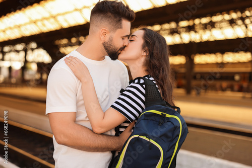 Long-distance relationship. Beautiful couple kissing on platform of railway station © New Africa