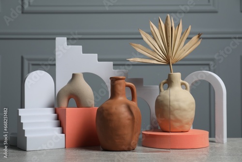 Clay flagons and other decorative elements on grey table photo