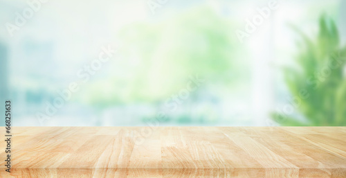 Selective focus.Empty of wood table top on blur of curtain with window and green from garden background.