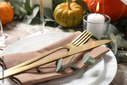 Beautiful autumn table setting. Plates, cutlery and decor, closeup