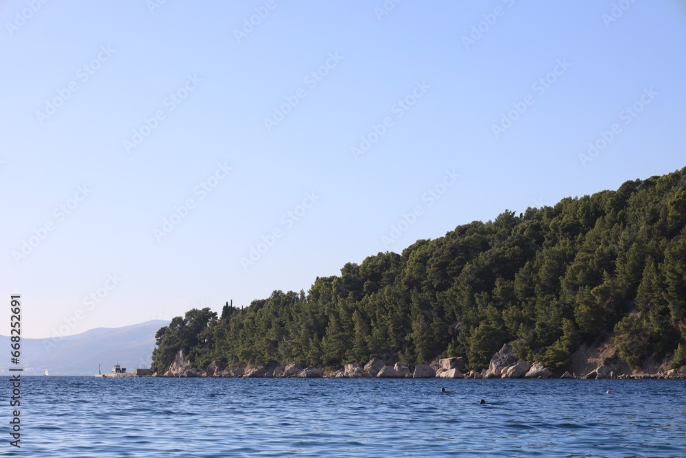 Picturesque view of beautiful sea and mountain with trees outdoors Picturesque view of beautiful sea and mountain with trees outdoors