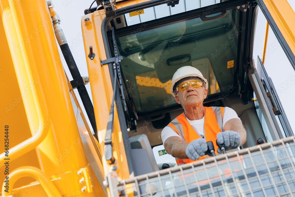Man driver builder operate crane or excavator at construction site with sun light. Portrait Industry worker Man driver builder operate crane or excavator at construction site with sun light. Portrait Industry worker