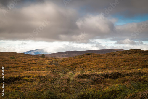A autumnal HDR image of a stalking track in the landscape of Sutherland, Scotland, with Ben Hee in the background shrouded in cloud