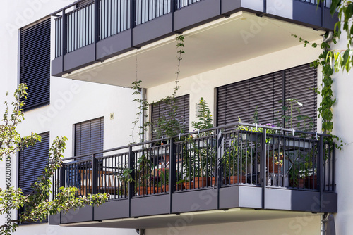 Balcony of Modern Building with Roller Blinds, External Shutters, Flower Pots. Balcony Garden Terrace. Exterior Balcony of Modern Facade Building.