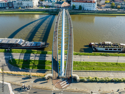 Krakow, Poland. Double suspension bridge under one arc: footbridge and bicycle bridge over Vistula River, called kladka Bernatka. Popular tourist and romantic destination. Aerial view photo