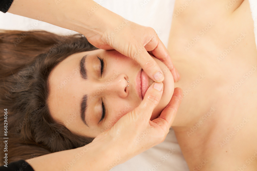 woman receiving a facial massage of the chin area