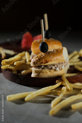 Tuna Egg Sandwich with fries and mayonnaise dip served in wooden board isolated on dark background side view of breakfast food