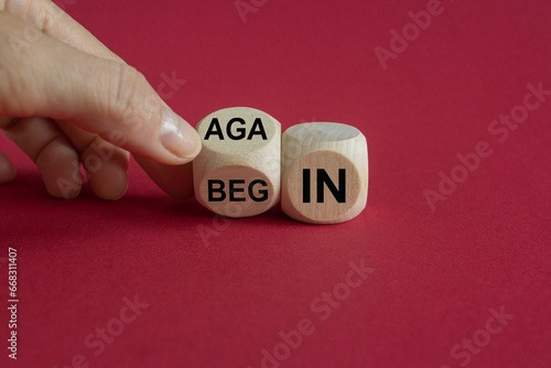 Businessman turns wooden cube and changes the words begin to again. Beautiful red background. Business and begin again concept. Copy space. photo