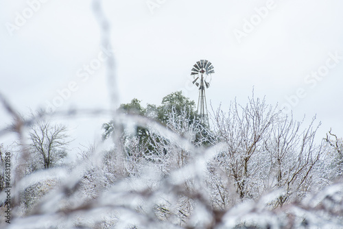 rustic windmill in icy winter storm
