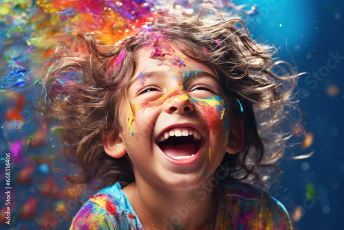 Portrait of a happy child playing with colored powder and paints. Holi festival.