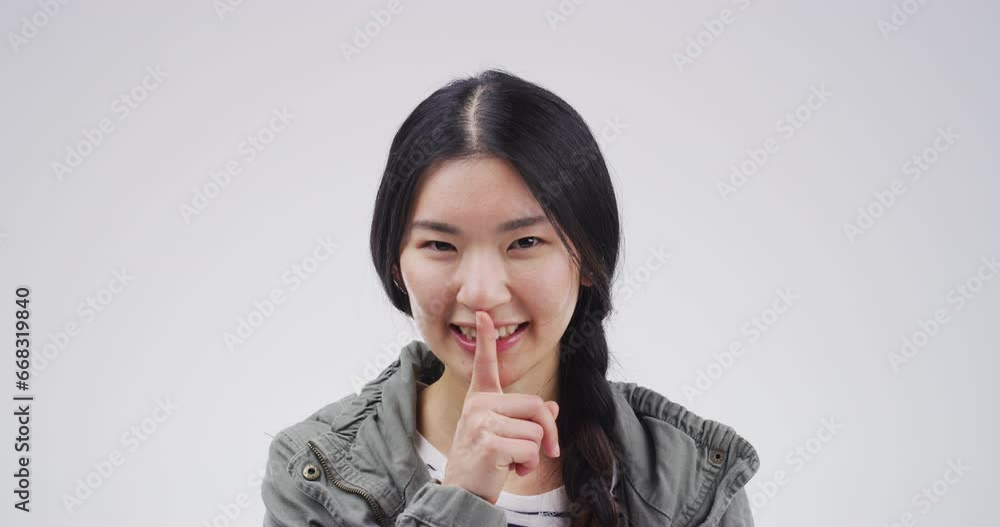 Woman, secret and finger in portrait by smile, silence and shush emoji in studio by white background. Asian female model, mystery and whisper on gossip, privacy and confidential for quiet in mockup Woman, secret and finger in portrait by smile, silence and shush emoji in studio by white background. Asian female model, mystery and whisper on gossip, privacy and confidential for quiet in mockup