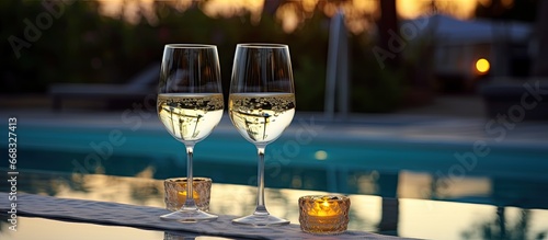 Romantic evening with two glasses of White wine near the pool photo