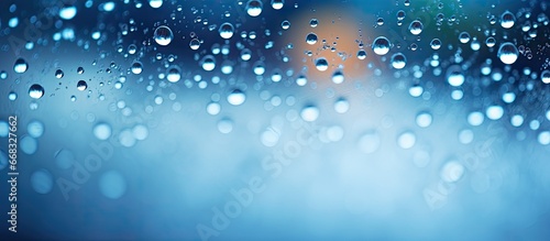 Raindrops on a blue glass backdrop street lights in bokeh an abstract autumn scene