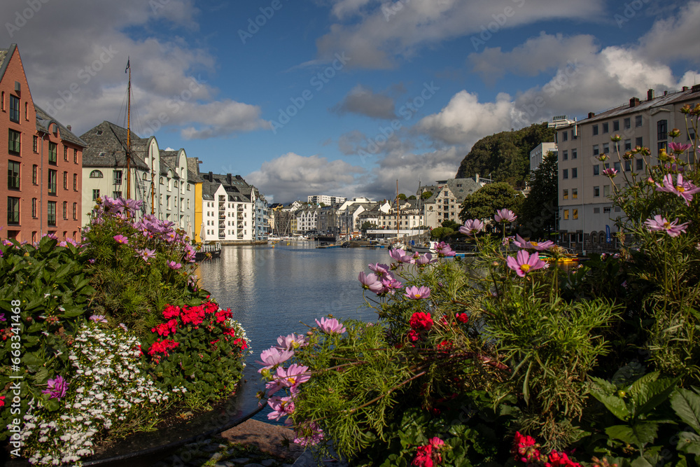 Beautiful image of the Alesund water canal with its Art Noveau buildings and flowers in the foreground